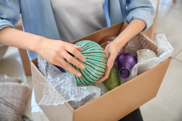 Woman packing carton box indoors. Moving house concept