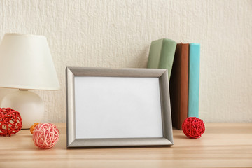 Composition with photo frame on table against light background