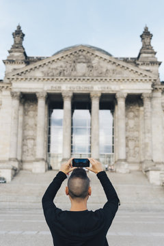 man taking a picture of the Reichstag, in Berlin.