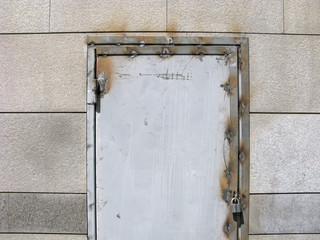 Arc welding on the old metal door. Weld seams on metal door frame and door hinge. Padlock on the door.
