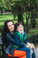 Fototapeta premium happy family in park. Young mother and her five year old son spending time outdoor on a summer day