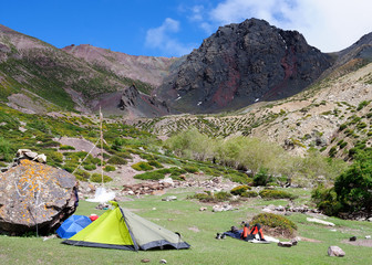 the tourist is resting by the tent, trekiing all over Karakorum tops in the Ladakh area, India