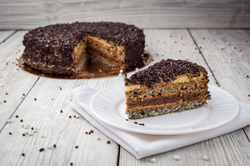 Dark chocolate vegan cake with candies and nuts on wooden background