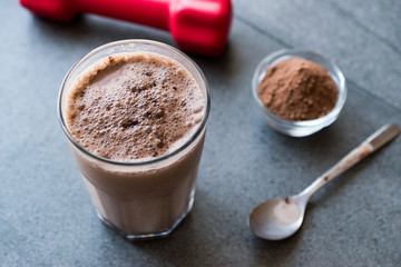 Chocolate Protein Shake Smoothie with Whey Protein Powder and Red Dumbbells