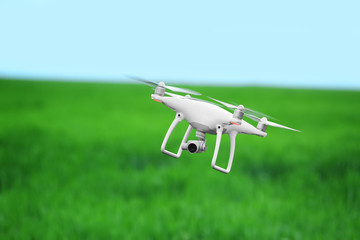 Modern quadcopter flying over field