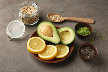 Avocado with ingredients for natural homemade cosmetics on grey background