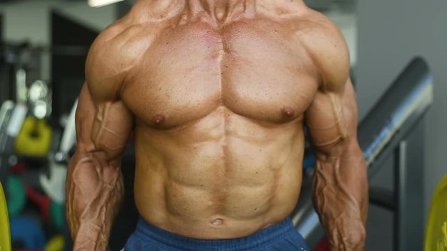 slow motion Brutal strong bodybuilder athletic man pumping up muscles workout bodybuilding concept background - muscular bodybuilder handsome men doing exercises in gym naked torso sport and diet