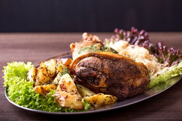 Roast pork knuckle with fried potato and sauerkraut
