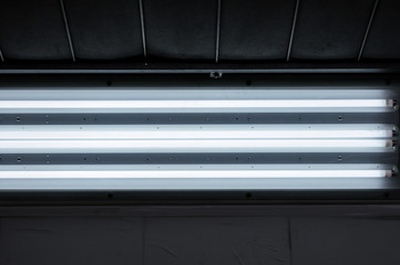 Obraz premium Industrial dark room with neon lights. Low light environment in cool tones. Car oven in details, working process elements, behind the scenes. Atmospheric light, street style vibes. Artificial lighting