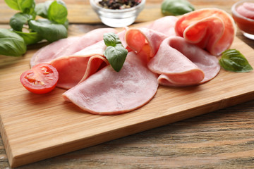 Board with delicious sliced ham on wooden table