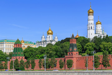 Fototapeta na wymiar Golden domes of churches in Moscow Kremlin on a blue sky background in sunny summer morning