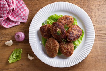 Patties or homemade burgers on white plate. View from above, top studio shot