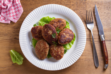 Patties or homemade burgers on white plate. View from above, top studio shot
