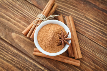 Aromatic cinnamon sticks and powder on wooden background