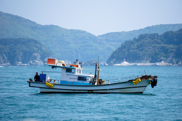Fishing boat anchors in the bay near islands in South Korea.