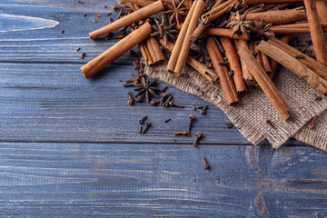 Cinnamon sticks and spices on wooden background