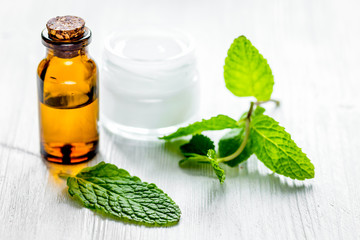 organic cosmetics with herbal extracts of mint on wooden backgro