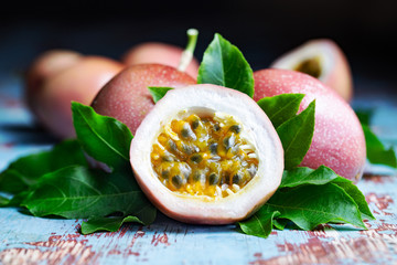 Fresh passion fruit with original leaves on blue wooden table