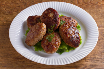 Patties or homemade burgers on white plate
