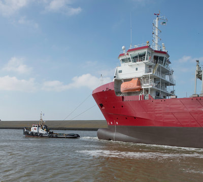 Freightship with towboat. Netherlands. Harbor. Coaster