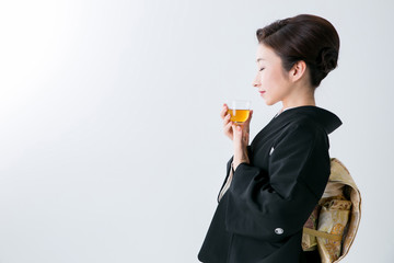お茶を飲む黒留袖の女性
