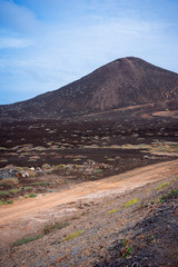 Desolates road over a surreal marslike landscape with majestic volcano creater in the distance. Sao Vicente Cape Verde