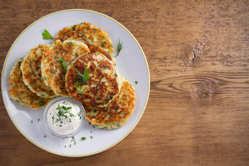 Mashed potato and cheese cakes, served with sour cream or yogurt. Potato Pancakes, Fritters. overhead, horizontal