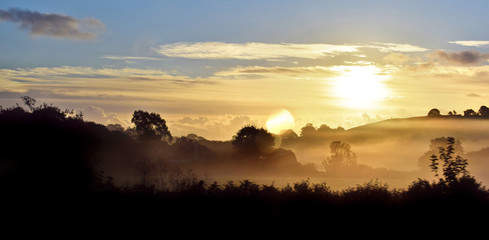 Sunrise over misty English countryside