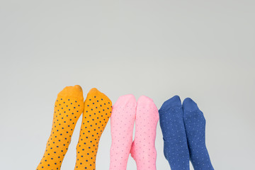 partial view of female legs in different colorful socks isolated on gray background