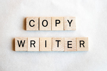 Copy writer written in wooden letters. Tan wood letters with black text on a white background. Business concept of writing, author