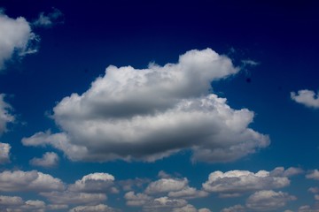 The fluffy white cloudscape in the blue sky.