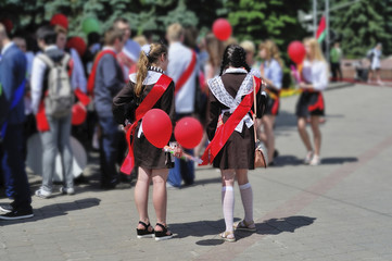 Girls in school uniform with colored balloons in hands. Parade of schoolchildren, graduates with bright balloons colorful in hands.