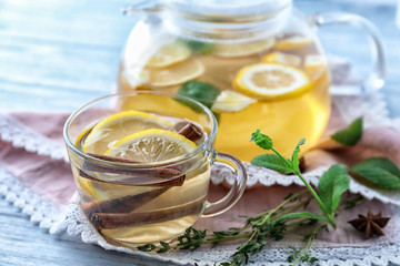 Cup of hot aromatic tea with cinnamon and lemon on table
