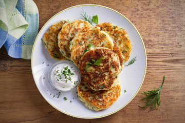 Mashed potato and cheese cakes, served with sour cream or yogurt. Potato Pancakes, Fritters. overhead, horizontal