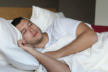 Obraz na płótnie Canvas Ethnic man deeply slept in comfy bed