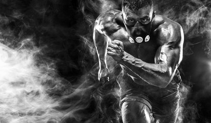 Strong athletic man sprinter in training mask, running, fitness and sport motivation. Runner concept with copy space. Dynamic movement. - obrazy, fototapety, plakaty