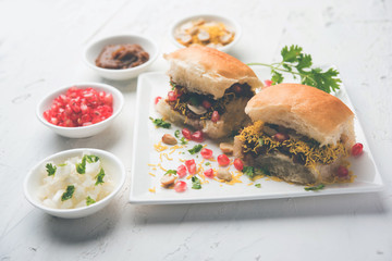 Dabeli is an Indian snack item served with Pomegranate Seeds and Cilantro in white ceramic plate. It's a popular Navratri Festival food