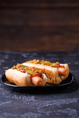 Photo of hotdogs on black plate