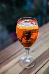 Aperol spritz cocktail in glass on wooden table on dark background in cafe