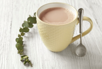 Cup of delicious hot cocoa on wooden background