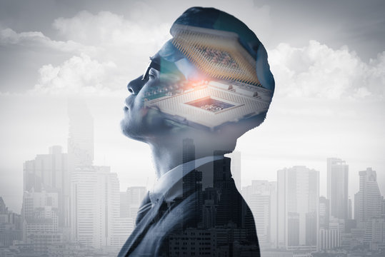The double exposure image of the businessman standing overlay with the CPU installing image and cityscape is backdrop. the concept of AI, electronics, intelligence, technology and internet of things.