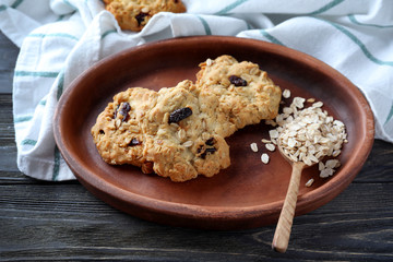 Plate with delicious oatmeal cookies on wooden background
