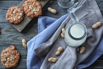 Bottle of milk and delicious oatmeal cookies on wooden background