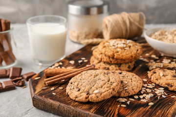 Board with delicious oatmeal cookies on table, closeup
