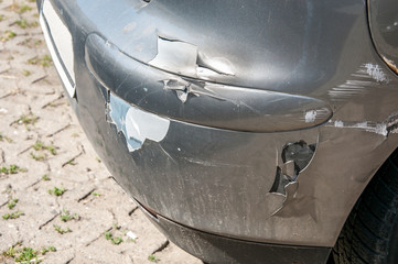 Damaged and broken car bumper with scratched paint in the accident or collision in the traffic or...