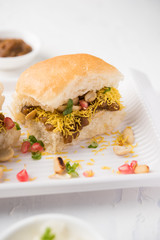 Dabeli is an Indian snack item served with Pomegranate Seeds and Cilantro in white ceramic plate. It's a popular Navratri Festival food