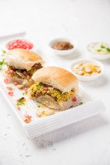 Dabeli is an Indian snack item served with Pomegranate Seeds and Cilantro in white ceramic plate. It's a popular Navratri Festival food