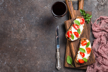 Crostini appetizers with cherry tomatoes, and cheese