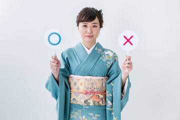 マルバツを持つ着物姿の女性
