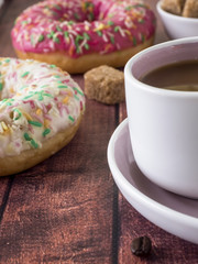 Donuts and coffee on wooden table. Top view with copy space